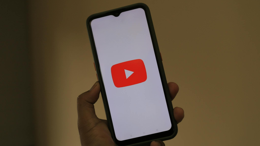 Close-up of a smartphone displaying the YouTube app logo on the screen.