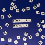 Scrabble tiles spelling 'Social Media' on a blue background, ideal for digital marketing themes.