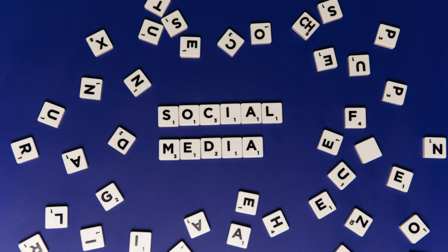 Scrabble tiles spelling 'Social Media' on a blue background, ideal for digital marketing themes.